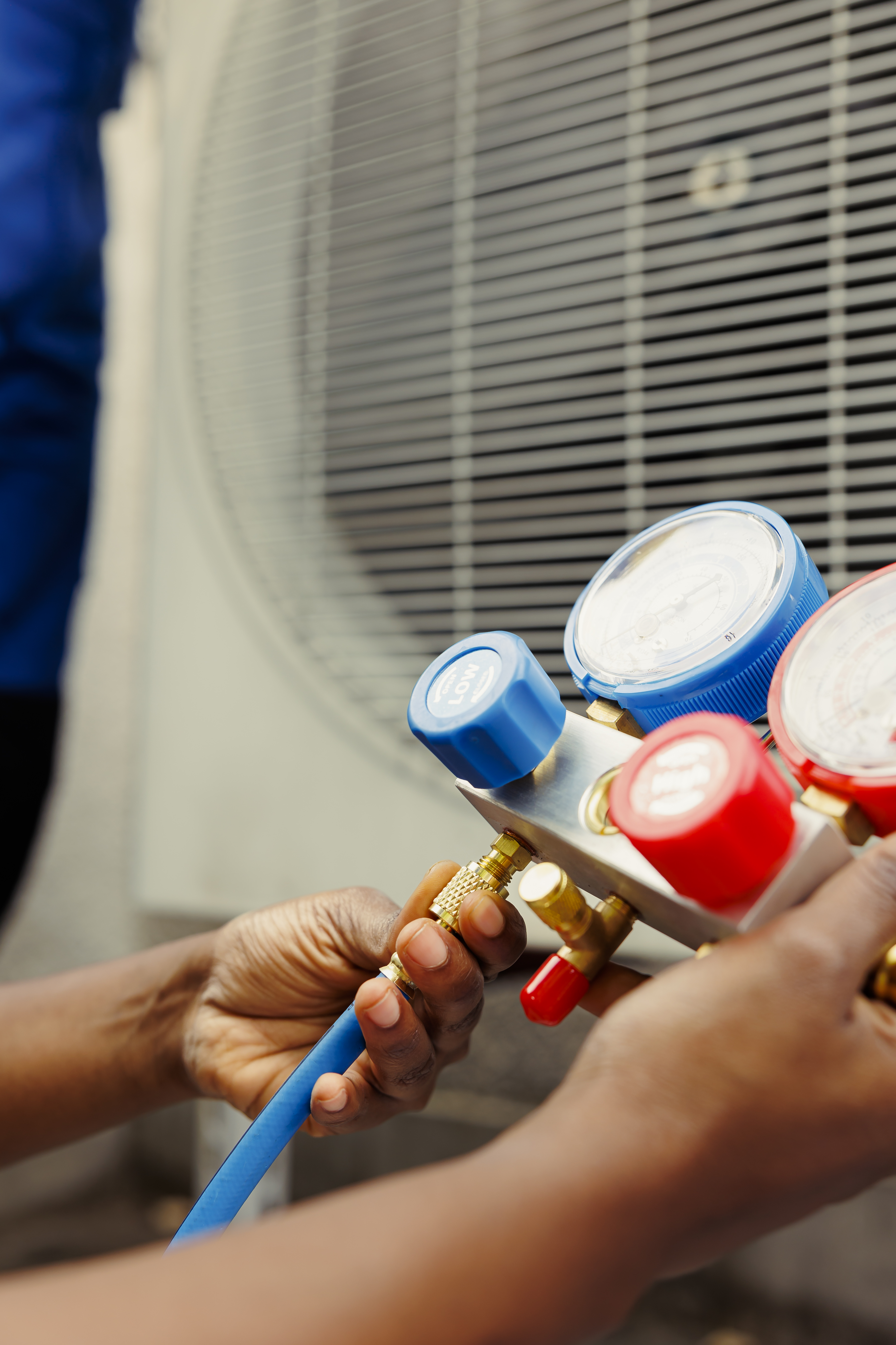 HVAC technician holding manifold gauges